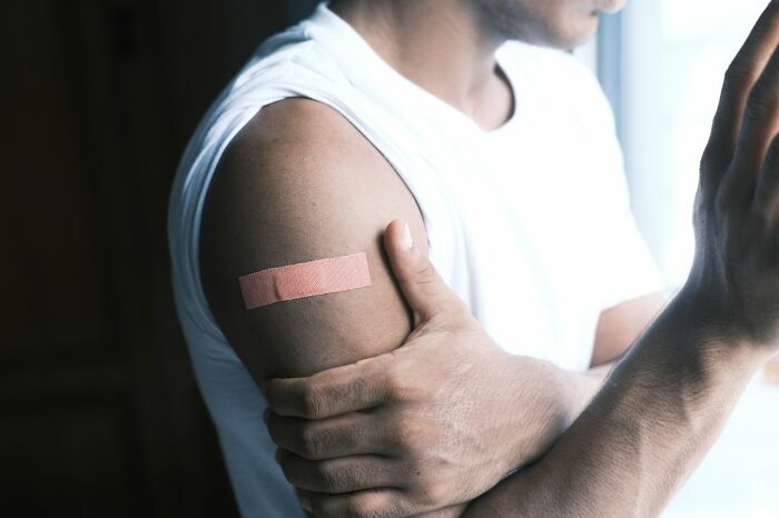 A man with a bandage on his arm, representing patients receiving care from ER staff.