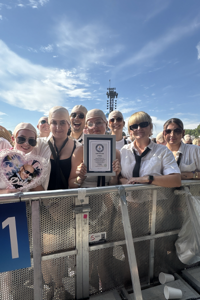 Fans of Pitbull holding a Guinness World Records Record Participation Certificate