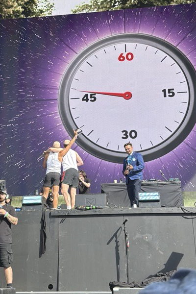 A Guinness World Records Adjudicator on a stage in front of a giant stopwatch