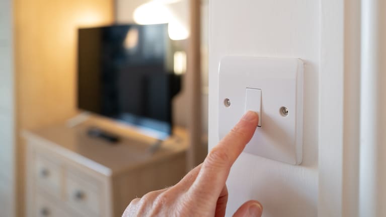 A home owner switching off a bedroom light.