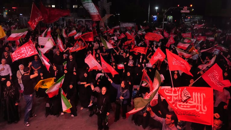 Pro-government demonstrators wave Iranian and religious flags in a gathering commemorating the late Iranian Supreme Leader Ayatollah Ali Khamenei at a square in Tehran.