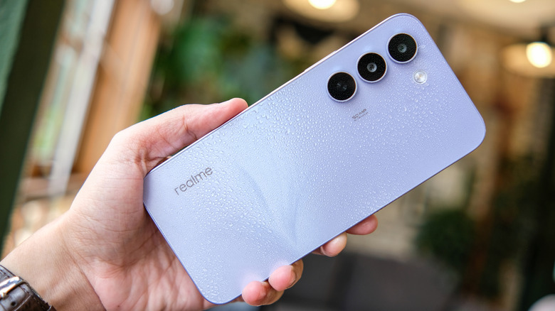 Hand holding a Realme smartphone