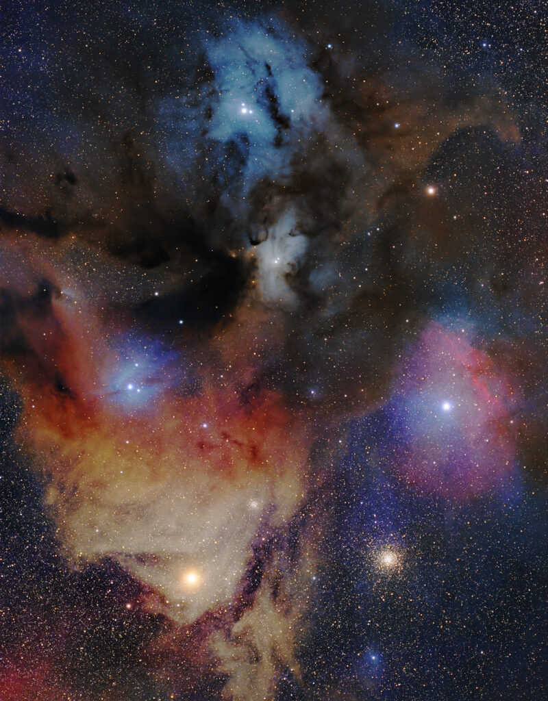 A handful of different types of clouds splatter across the image, with bright stars embedded within. Dust blocks some parts of the clouds. Many small stars cover the background, with a cluster of them sitting in the bottom right beneath all the clouds.