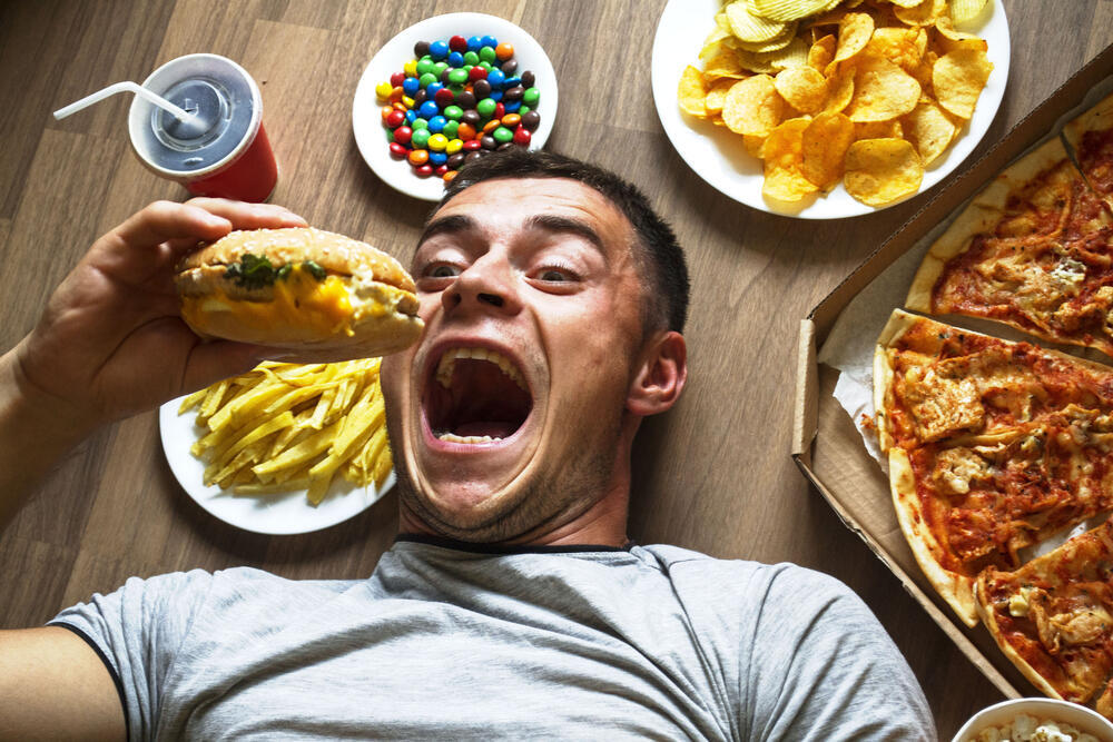 Ultra-processed food makes weight regulation harder (Photo: Shutterstock) גבר אוכל מזון מהיר