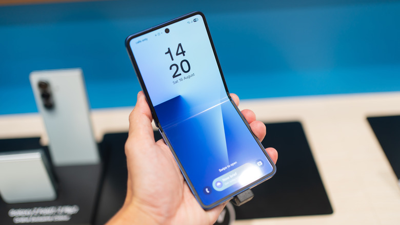 Hand holding a Samsung Galaxy Z Flip7 at a store
