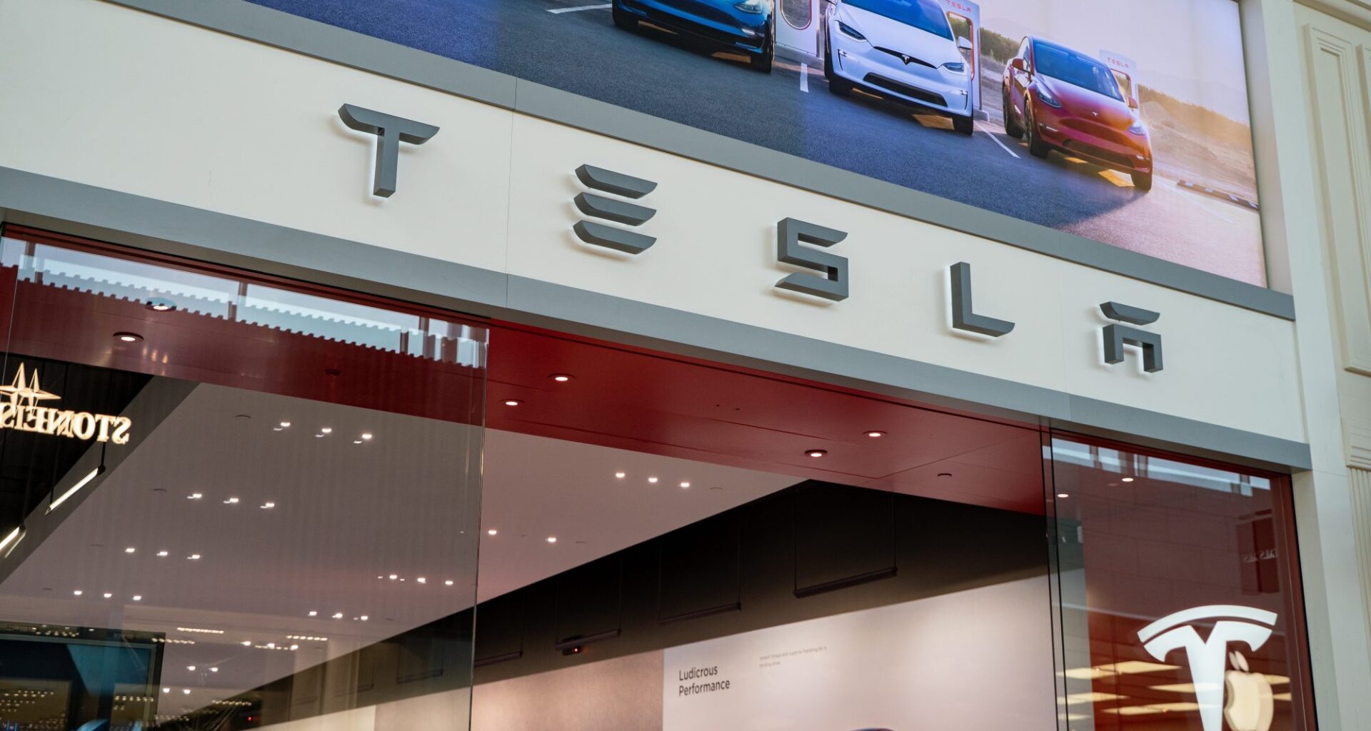 Close up of Tesla storefront signage at shopping mall.