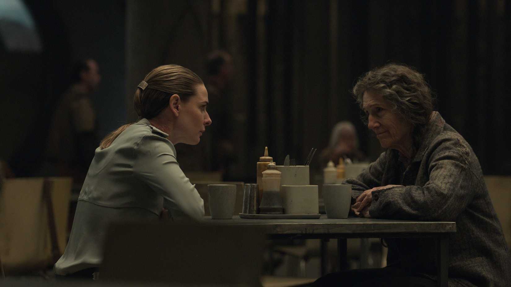Juliette Nichols (Rebecca Ferguson) sits in the cafeteria and talks with Martha Walker (Harriet Walter) in Silo