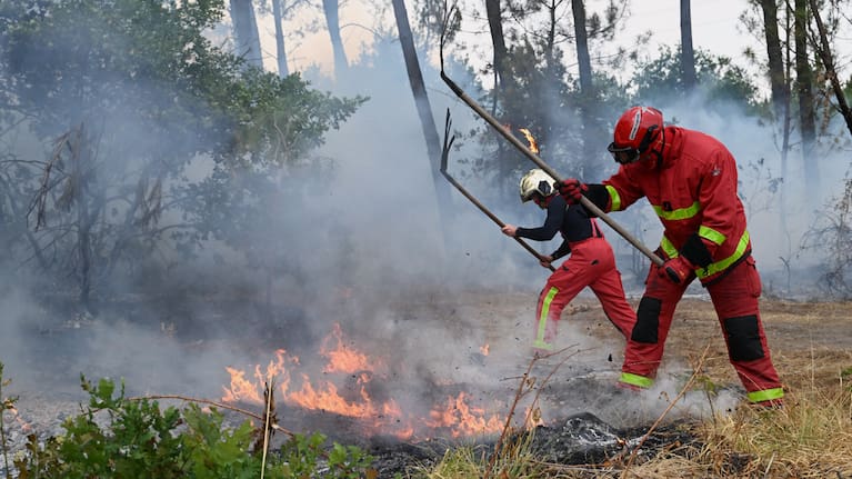 Firefighters battle a wildfire near Marcheprime, outside, Bordeaux, France, Sunday, July 26, 2026.
