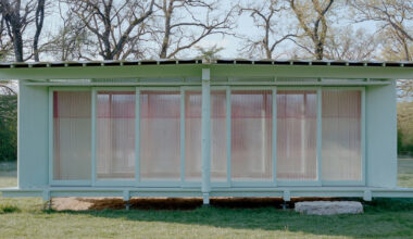 sliding timber frames and reused materials shape reversible pavilion within swiss meadow
