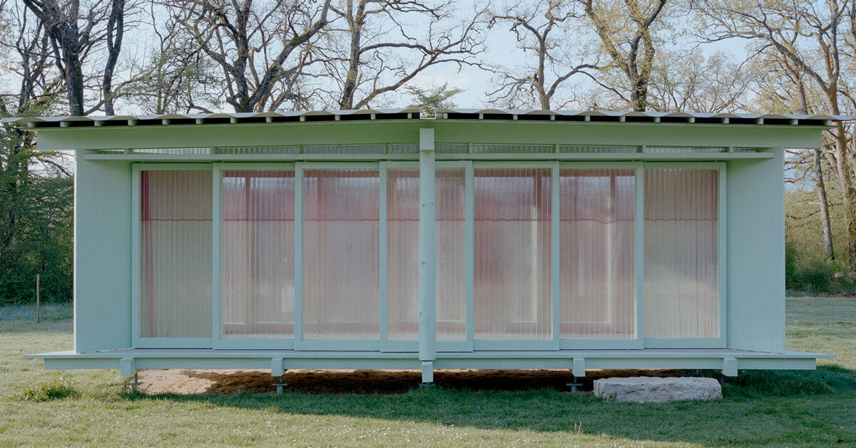 sliding timber frames and reused materials shape reversible pavilion within swiss meadow
