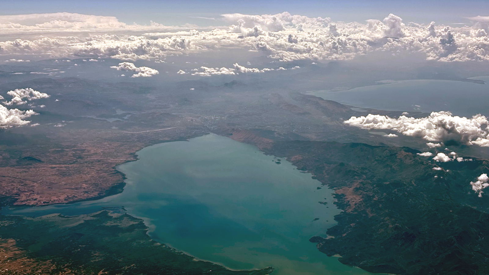 An aerial view of Lake Skadar with the Adriatic Sea in the background