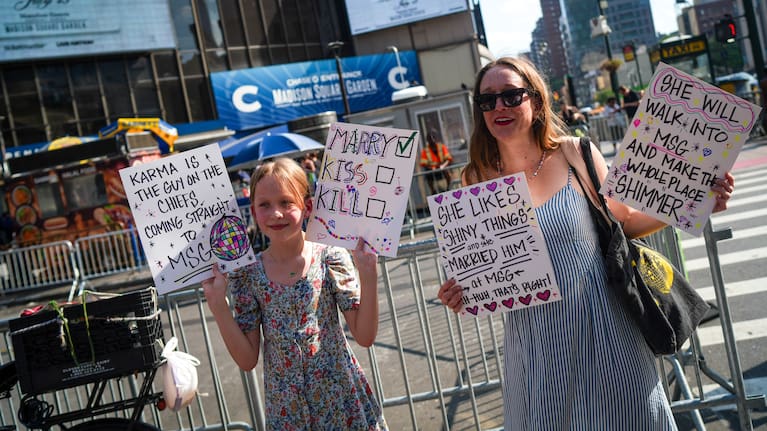 Taylor Swift fans hold signs outside of Madison Square Garden ahead of a reported wedding between singer Taylor Swift and National Football League player Travis Kelce.