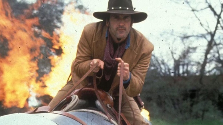 Brisco riding away from an explosion