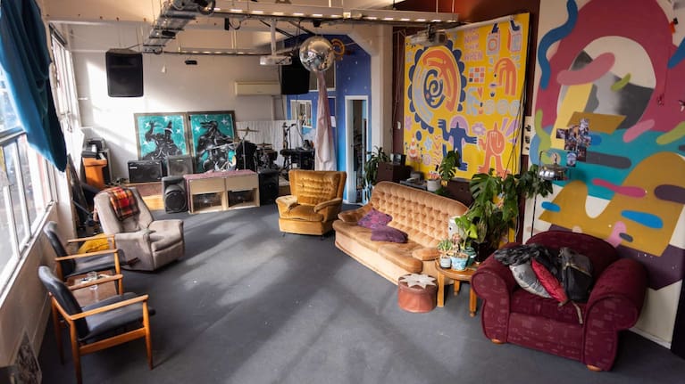 The front room is full of murals and speakers and mismatched vintage furniture.