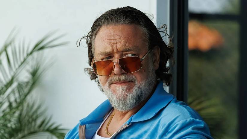 Russel Crowe wearing sunglasses and a blue jacket in The Get Out