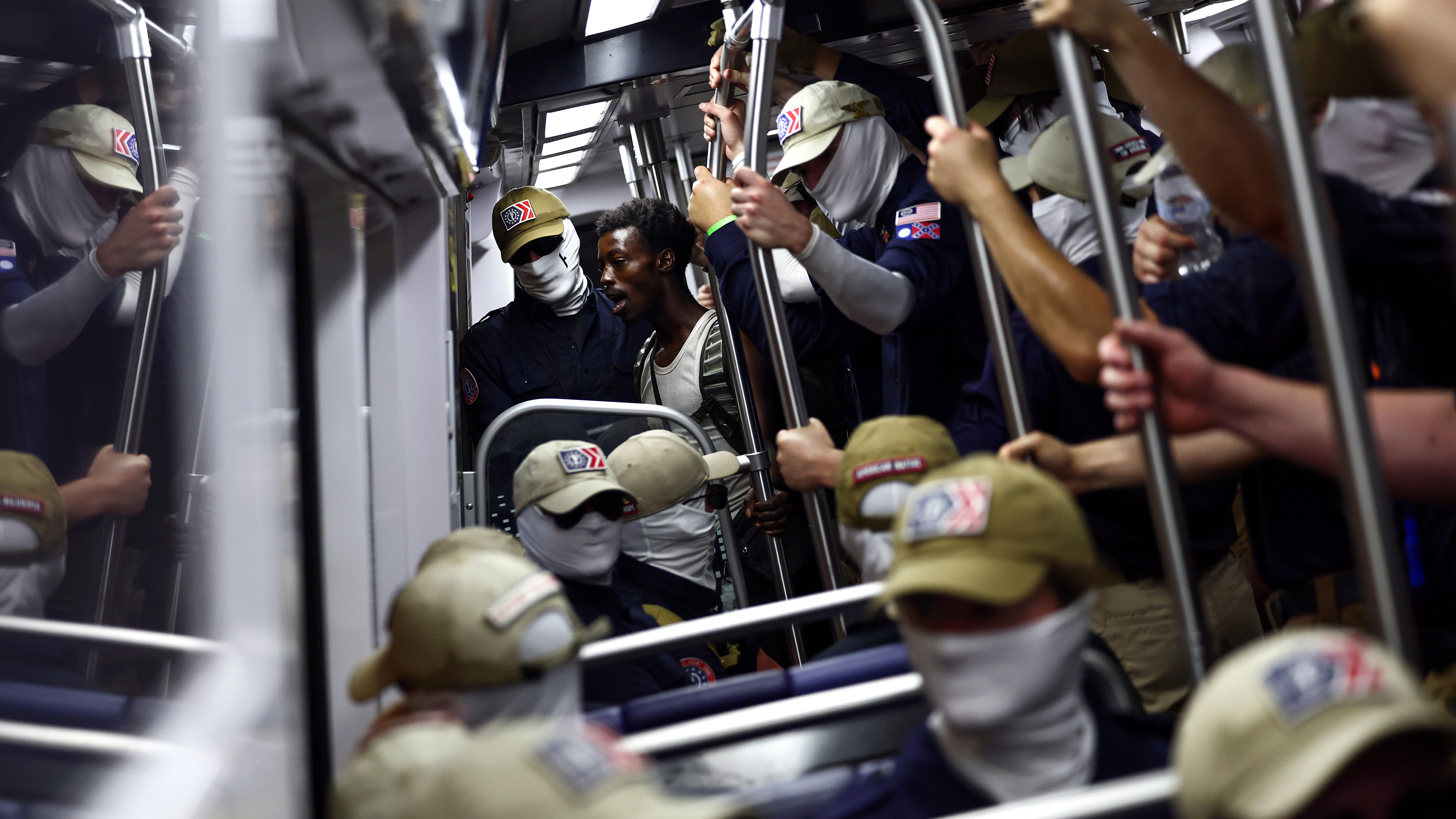 WASHINGTON, DC - JULY 04: A passenger (C) looks on as members of the white supremacist group Patriot Front ride the Washington Metro on July 04, 2026 in Washington, DC. Numerous events, activities, and fireworks are planned in celebration of America's 250th Anniversary. (Photo by Finn Gomez/Getty Images)