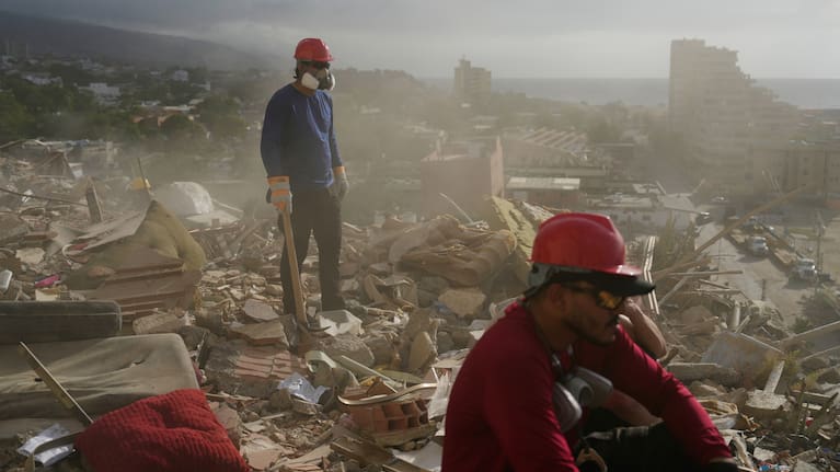 Rescue workers and volunteers search through the rubble of a building collapsed during the earthquakes.