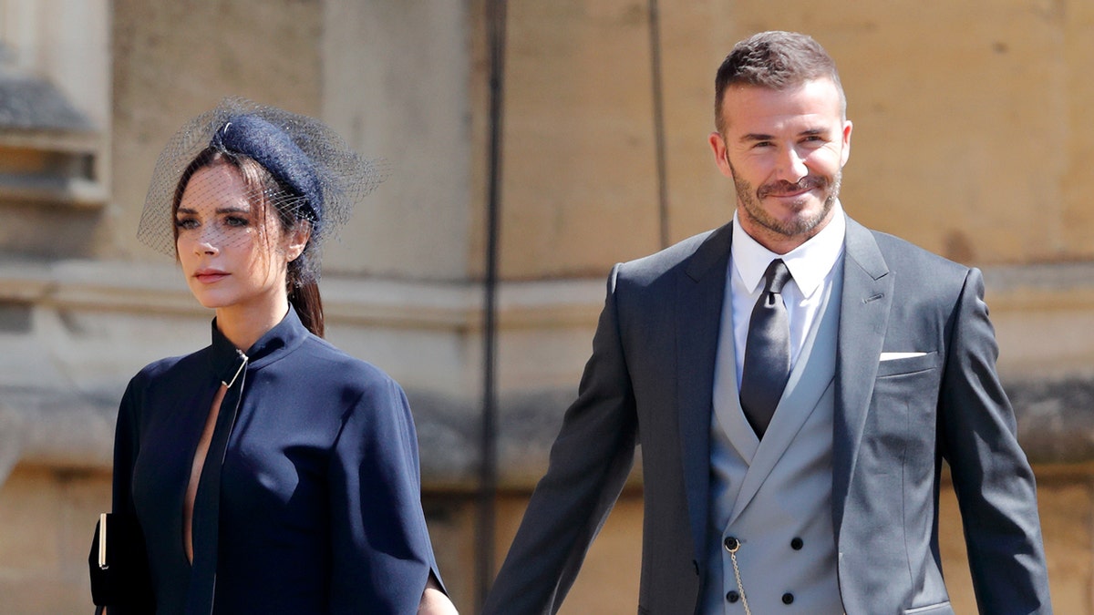 Victoria Beckham and David Beckham holding hands walking at Windsor Castle