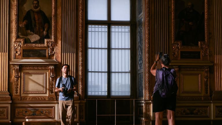 Visitors take a picture of the window which was broken during the reopening to the public of the Apollo Gallery, at the Louvre museum in Paris, Wednesday, July 22, 2026. (Source: Lou Benoist/Pool Photo via AP)