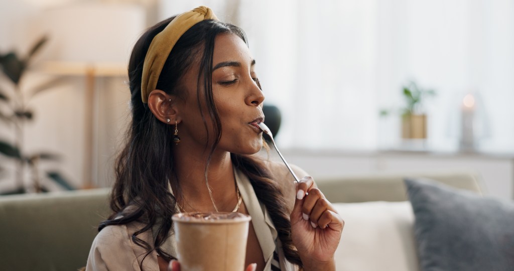 Woman eating ice cream in her living room.