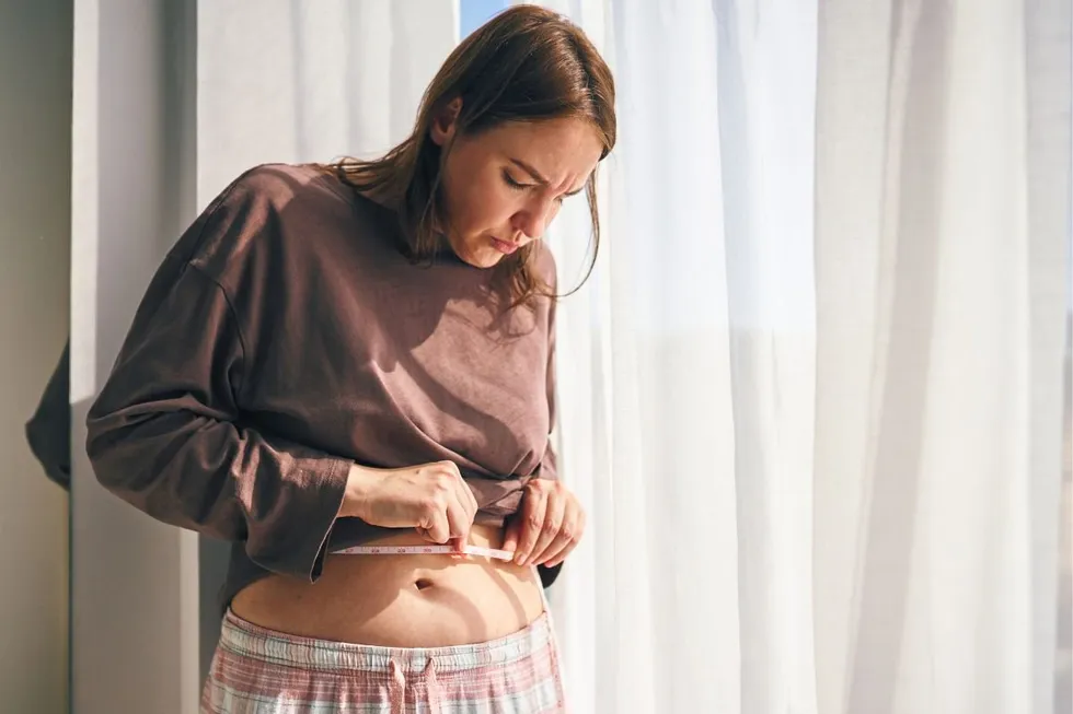 WOMAN MEASURING WAIST