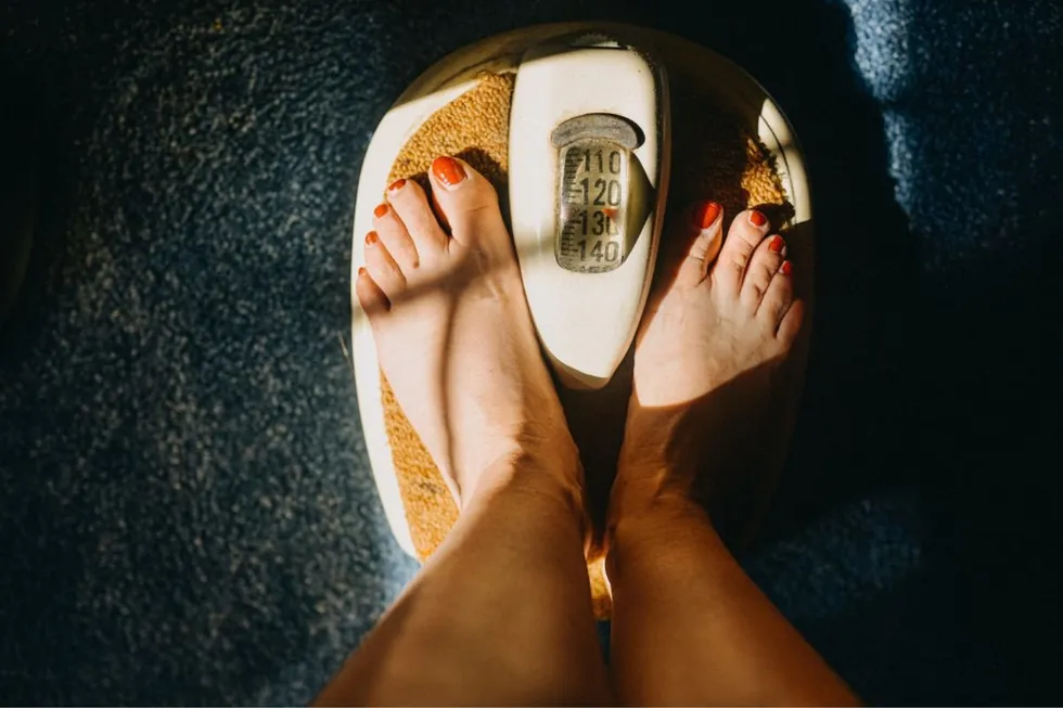 WOMAN STANDING ON SCALES