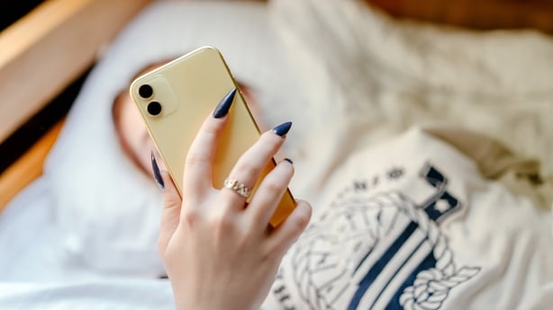 Teenage girl with long nails holding a mobile phone