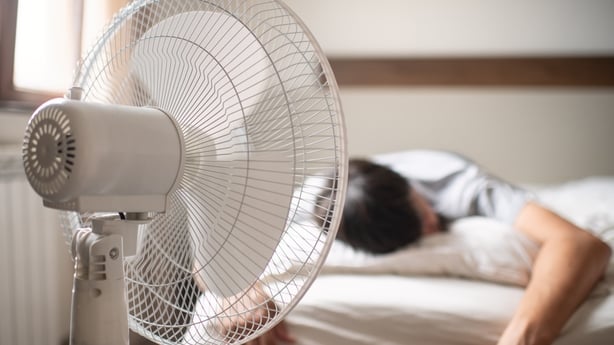 Man sleeping near an electric fan