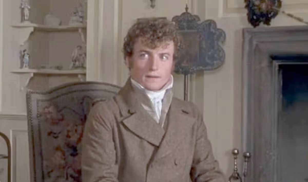 A man in brown coat looks to one side