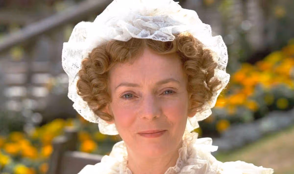 A woman in a white bonnet smiles