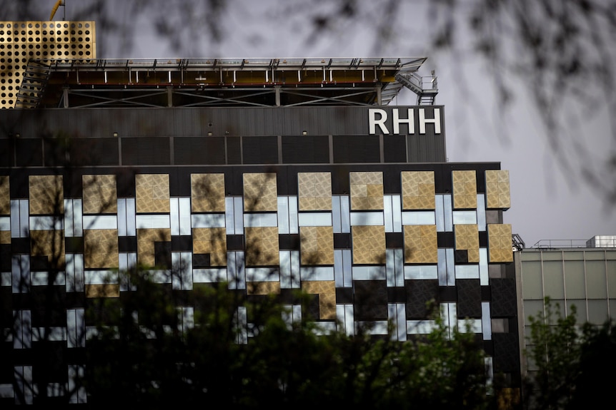 A photo of Royal Hobart Hospital's K Block ward framed against a dark and cloudy sky.