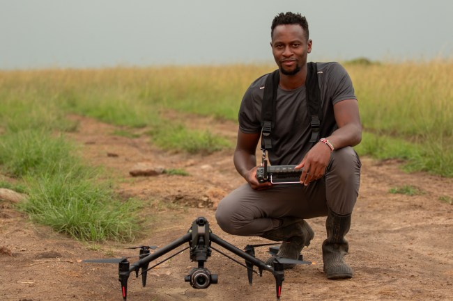 Anthony Njuguna prepares to capture footage of Summer's Pride via drone. (National Geographic/Joe Treddenick)