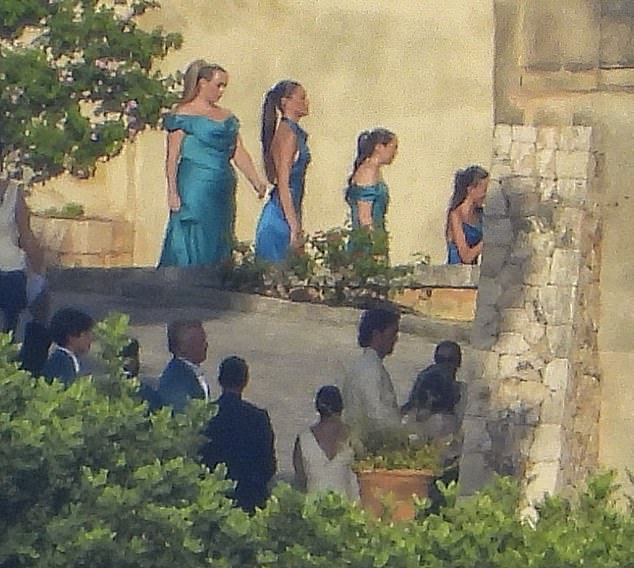The bridesmaids wore mismatched satin gowns in shades of teal, turquoise and sapphire blue