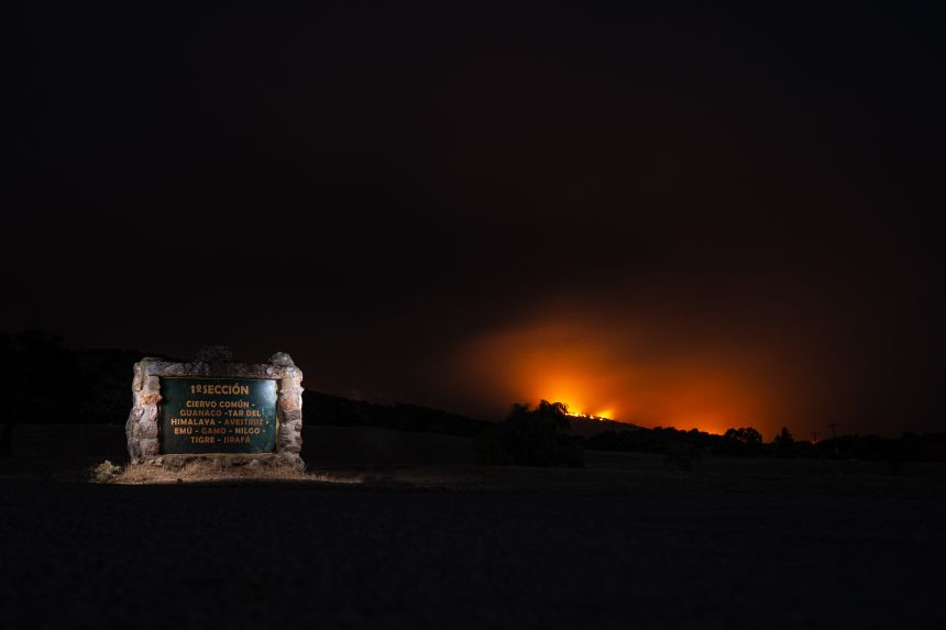 Fires rise in the distance, behind the entrance to Safari Madrid.