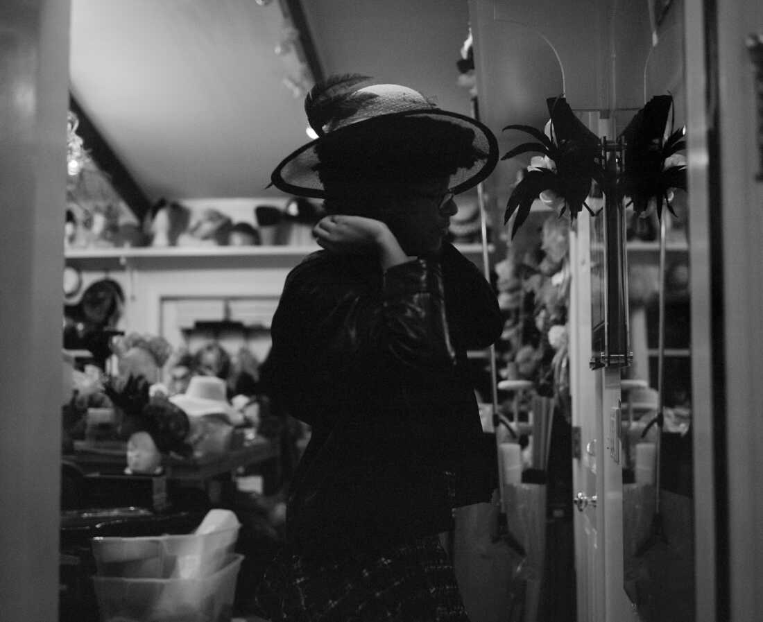 Mikaela Gumbel, 20, looks in a mirror while wearing one of the many hats in her grandmother’s hat studio in Westchester County, N.Y. The studio holds years of her handcrafted work — each piece shaped with care, memory and attention to detail.