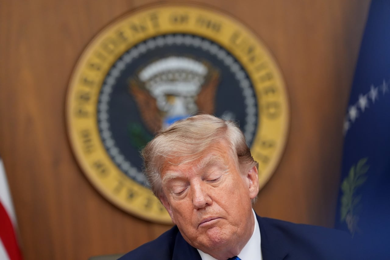 A man in a suit looks down.