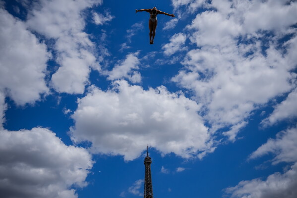 A diver in action during High Dive practice as the Eiffel Tower is seen in the background at the European Aquatics Championships in Paris, Wednesday, Aug. 5, 2026. (AP Photo/Aurelien Morissard)