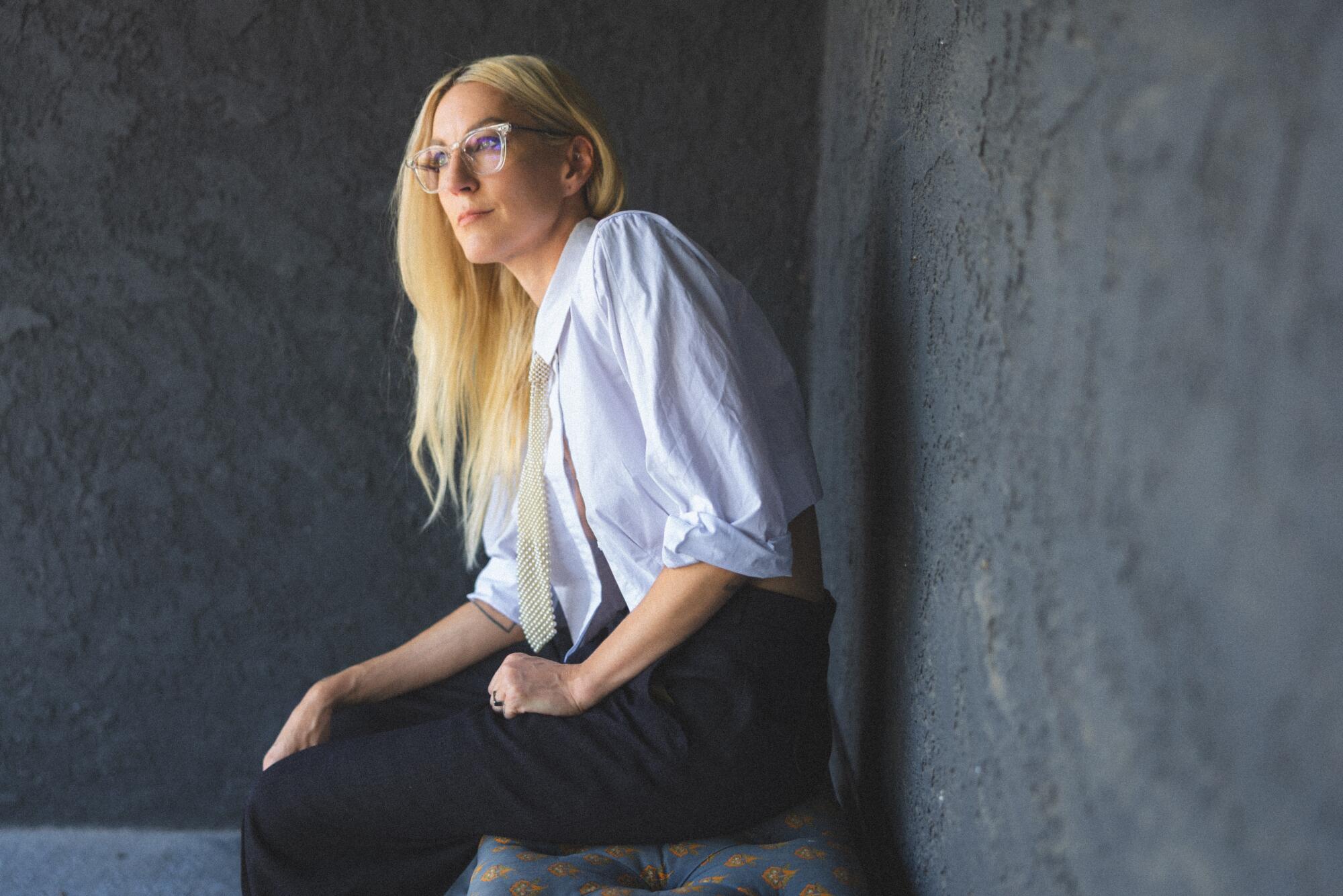 A woman poses in a crisp white shirt.