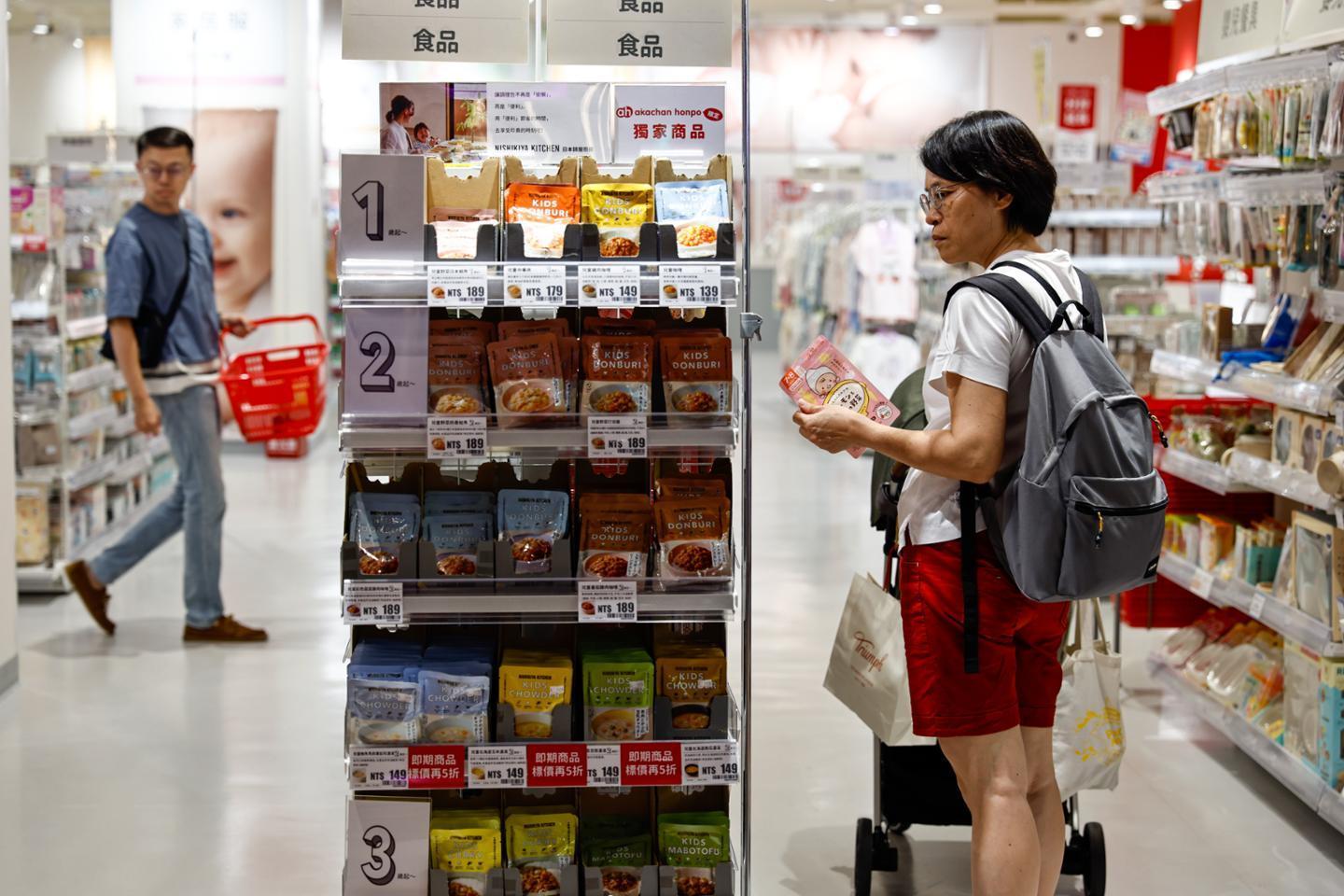 A woman looks at product prices at a department store in Taichung, Taiwan, on July 31. Yonhap