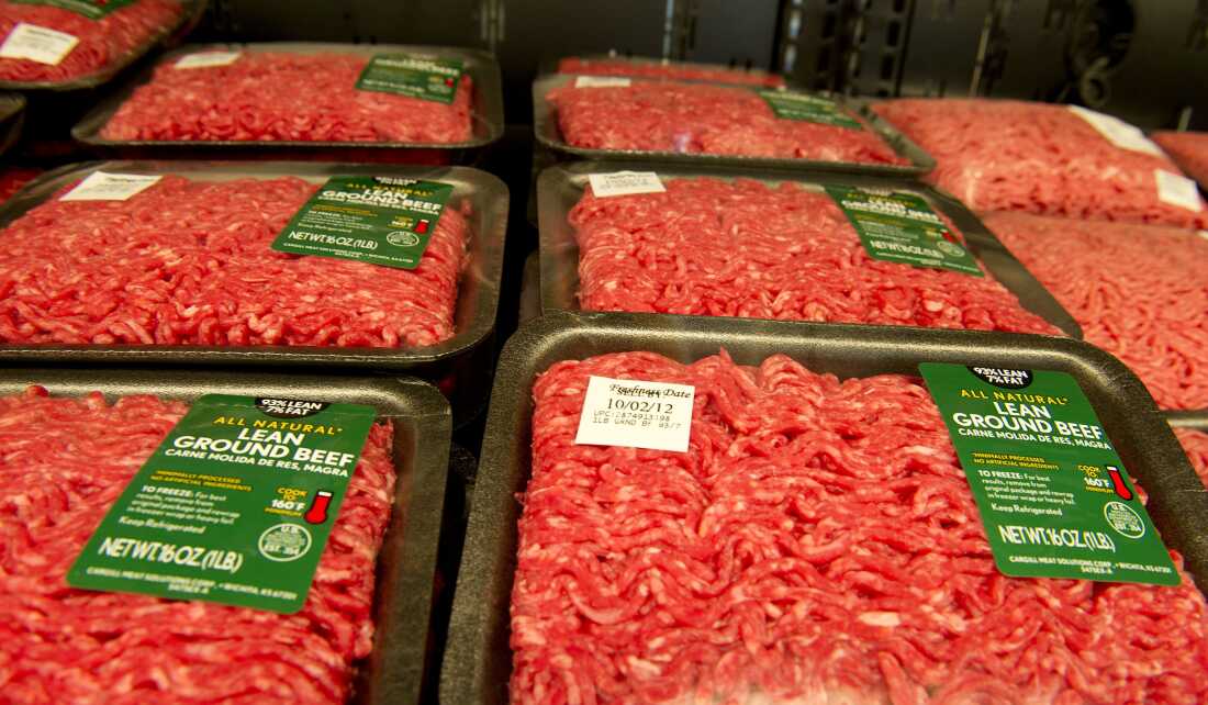 Packages of lean ground beef are on display for sale in a store.