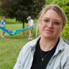 Amber Petersen sits in the backyard of her parents’ home in Iowa City, Iowa on Sunday, June 14, 2026. Petersen lives in Mason City, Iowa with her husband and three children. (Cliff Jette for NPR)