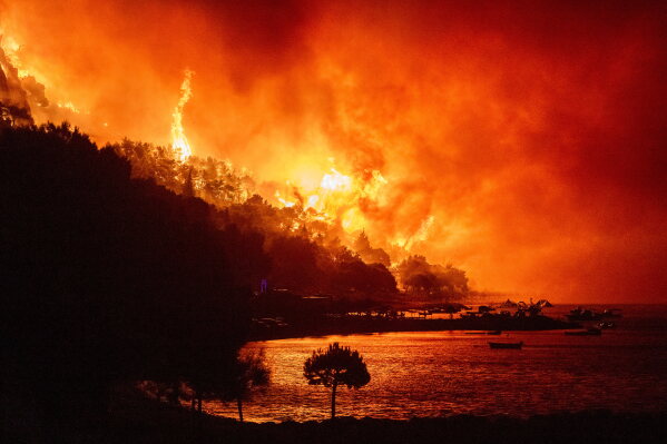 A wildfire approaches a beach on the Adriatic coast near Omis, southern Croatia, early Friday, Aug. 14, 2026. (AP Photo/Tom Dubravec)