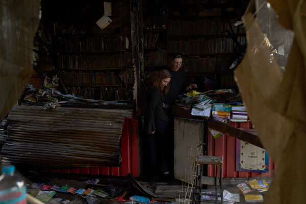 People view damage the day after a Russian missile attack at a city book market in Kyiv, Monday, Aug. 17, 2026. (AP Photo/Francisco Seco)