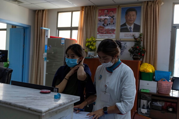 Nurses at their station near a portrait of Chinese President Xi Jinping at the Xizang Autonomous Region Hospital of Tibetan Medicine in Lhasa, in western China's Tibet Autonomous Region on Wednesday, July 22, 2026 as seen during a government organized visit for foreign journalists. (AP Photo/Ng Han Guan)