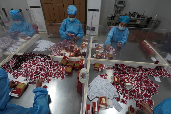 Workers pack traditional Tibetan medicine produced by the Xizang Gansu Tibetan Medicine Co. Ltd in Lhasa, in western China's Tibet Autonomous Region on Wednesday, July 22, 2026 as seen during a government organized visit for foreign journalists. (AP Photo/Ng Han Guan)