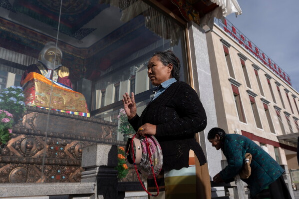 Women perform circumambulations around a statue of Tibetan medical master Yutok Nyingma Yonten Gonpo outside the Xizang Autonomous Region Hospital of Tibetan Medicine in Lhasa, in western China's Tibet Autonomous Region on Wednesday, July 22, 2026 as seen during a government organized visit for foreign journalists. (AP Photo/Ng Han Guan)