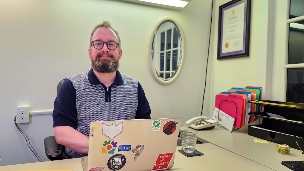 Charlies is sitting at a desk with his laptop computer in front of him.