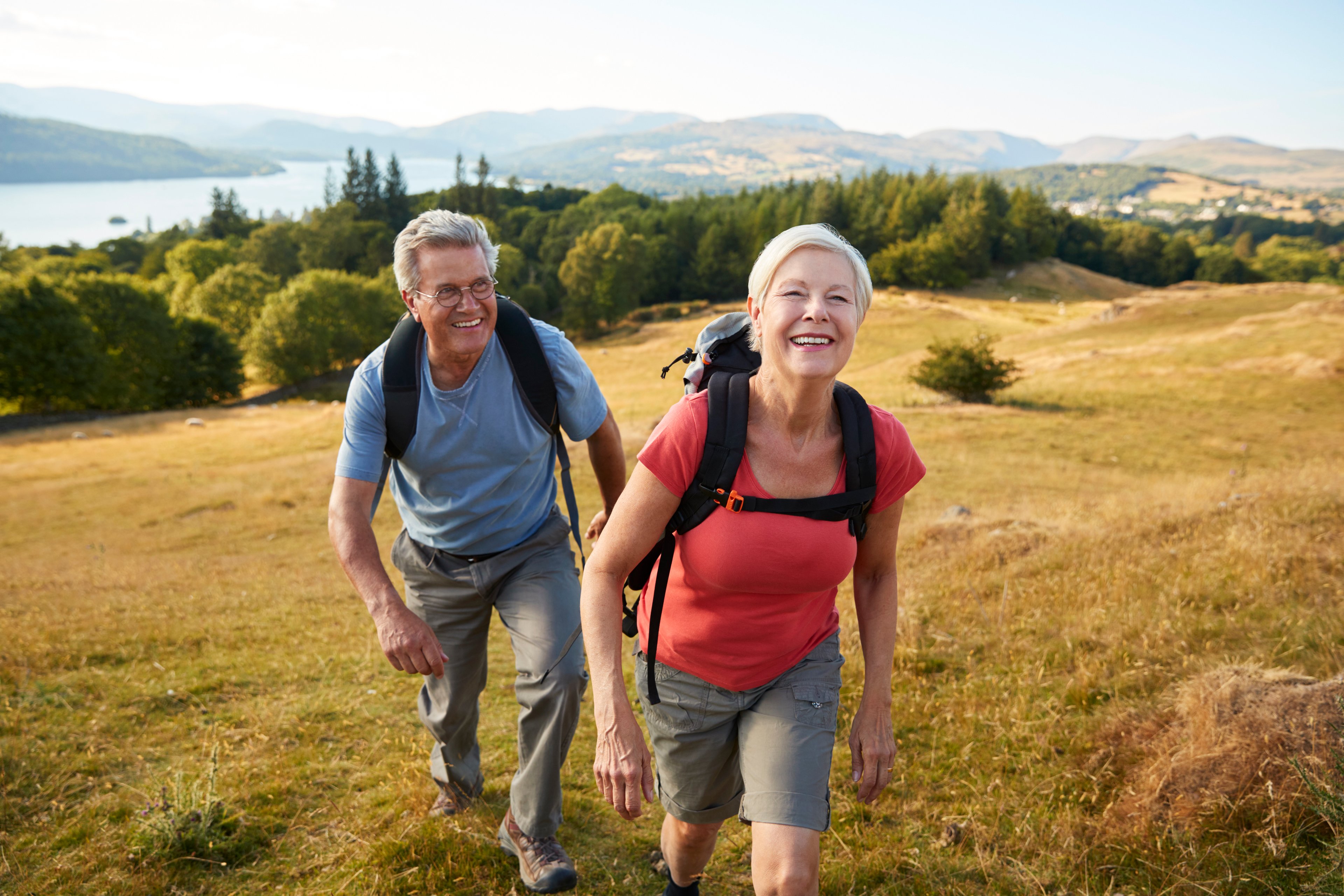 Two people hiking outside with backpacks on.