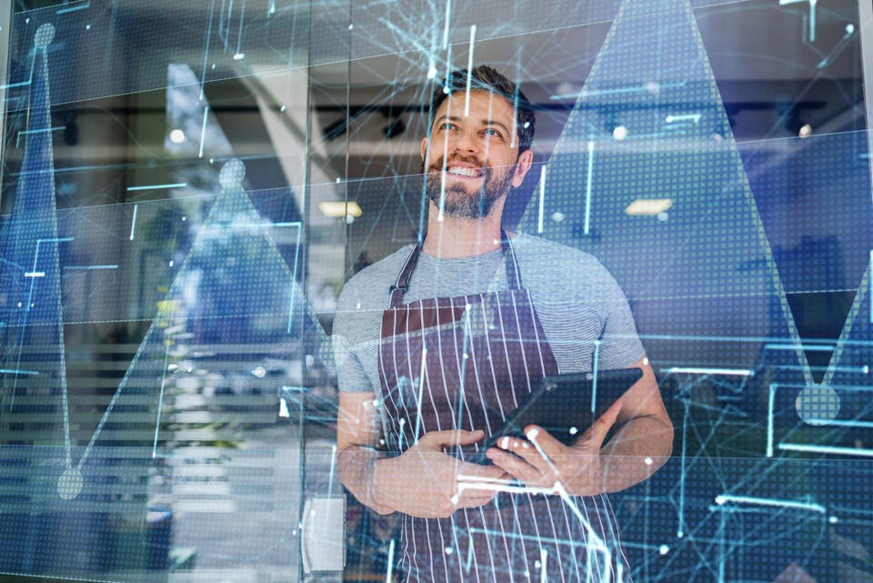 Small business owner analyzing digital growth charts with a tablet