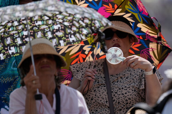 Faithful shelter from the hot sun as Pope Leo's XIV arrives for his weekly general audience in St. Peter's Square at The Vatican, June 24, 2026. (AP Photo/Alessandra Tarantino, File)